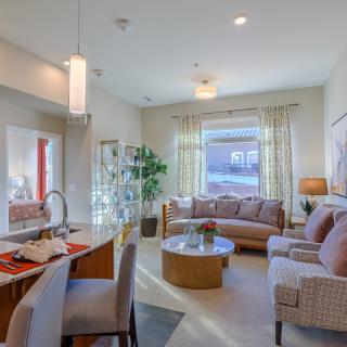 A modern and cozy living room with natural light, featuring stylish furniture and open space.