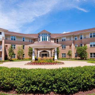 Exterior view of a large residential building with a landscaped entrance.
