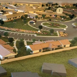 A scale model of a residential community showcasing buildings, landscaping, and parking areas.