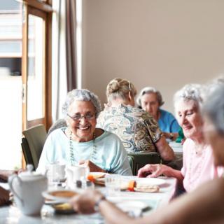 A group of seniors enjoying a meal together indoors.