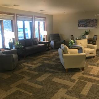 A cozy living room with comfortable seating, large windows, and warm lighting.