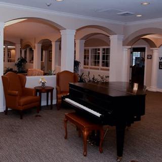 A cozy lounge area featuring a grand piano and comfortable seating.