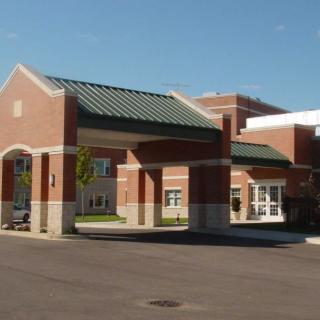 A modern healthcare facility with a prominent entrance, featuring brick and concrete construction.
