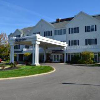 A large hotel building with a prominent entrance and landscaped surroundings.