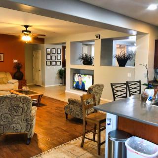 A cozy living room with an open floor plan that includes a kitchen area, stylish furniture, and decorative elements.