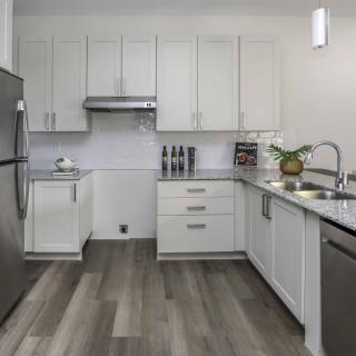 A modern kitchen with white cabinets and stainless steel appliances.