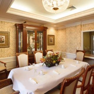 An elegantly decorated dining room with a table set for a formal meal, complete with a chandelier and classic furniture.