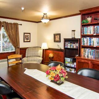 A cozy living space featuring a dining table, comfortable seating, and a bookshelf filled with books.