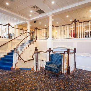 A well-lit lobby with a staircase and seating area.