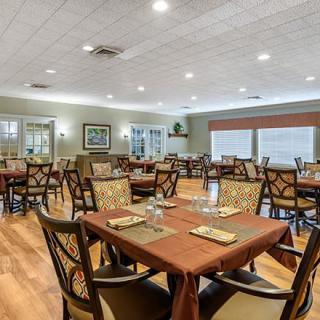 A spacious dining room with neatly arranged tables and chairs, featuring tasteful decor and ample lighting.