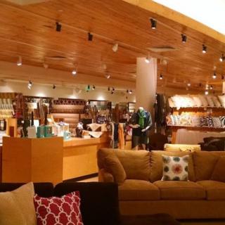 A cozy cafe interior with comfortable seating and a retail section.