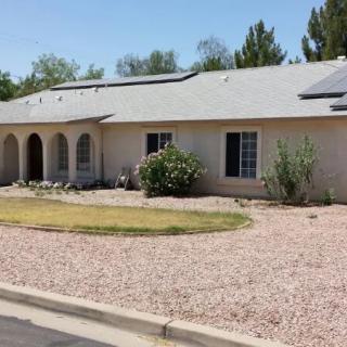 A single-story house with a desert landscape yard and arched entryway.