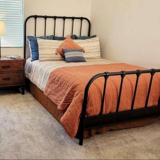 A cozy bedroom with a neatly made bed and a nightstand.