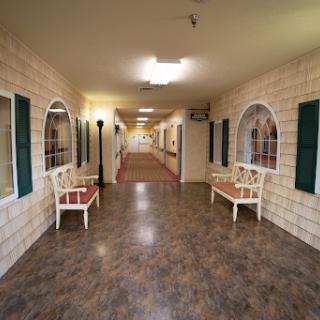 A well-lit hallway with decorative walls and benches on either side.
