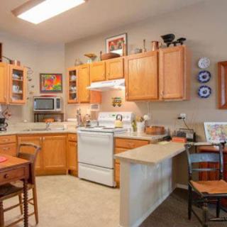 A cozy kitchen with wooden cabinets, modern appliances, and a small dining area.