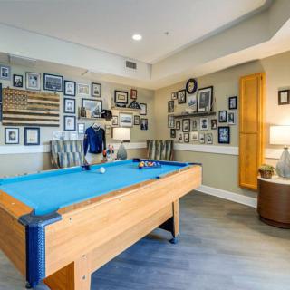 A stylish game room featuring a pool table and walls adorned with numerous framed pictures.