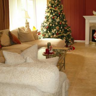 A cozy living room decorated for the holidays with a Christmas tree and a fireplace.