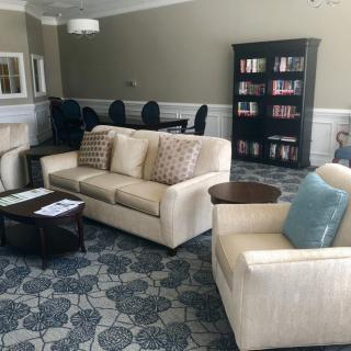 A cozy living room with comfortable seating, a bookshelf, and a stylish carpet.