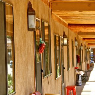 A long outdoor corridor of a motel with rustic architecture.