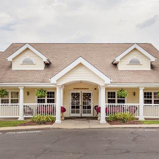 A charming residential building with a porch and symmetrical design.