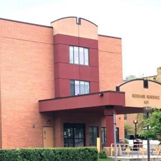 A modern brick building with multiple stories and an entrance canopy.