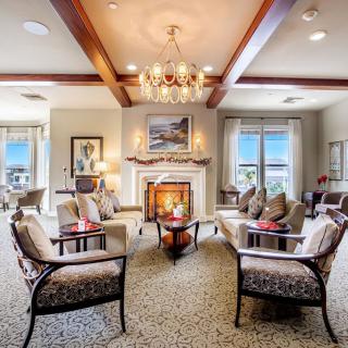 A luxurious living room with elegant seating, a chandelier, and a cozy fireplace.