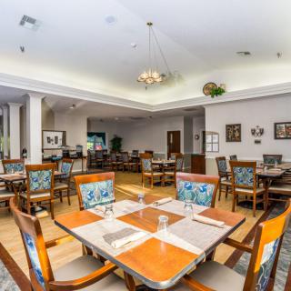 A spacious dining area with elegantly set tables and chairs, featuring tasteful decor.