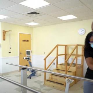 A physical therapy room equipped with rehabilitation stairs and exercise bars.