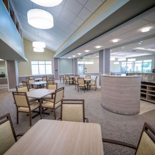 A modern and spacious dining area with neatly arranged tables and chairs.