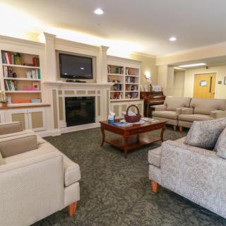 A cozy living room with sofas, a fireplace, and bookshelves.