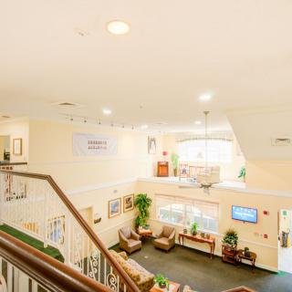 A bright and welcoming lobby area with stairs, comfortable seating, and decorative elements.