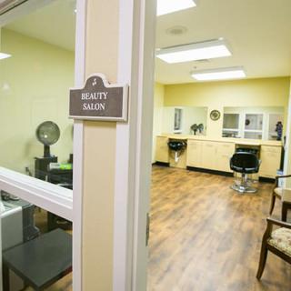 An empty beauty salon featuring styling stations, chairs, and mirrors.