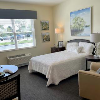A cozy and inviting bedroom with natural light, featuring a comfortable bed, stylish furniture, and decorative artwork.