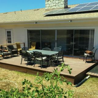 A backyard patio with outdoor furniture and solar panels on the roof.