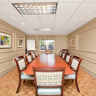 A well-furnished conference room with a long meeting table and chairs.