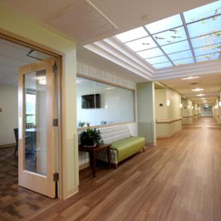 A well-lit hospital corridor featuring a waiting area with modern furniture.