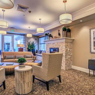 A modern living room with elegant seating around a stone fireplace, complemented by contemporary lighting and decor.