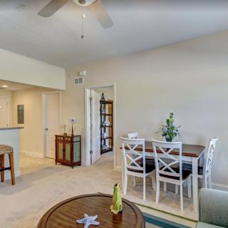 A cozy living and dining area with white furniture and warm lighting.