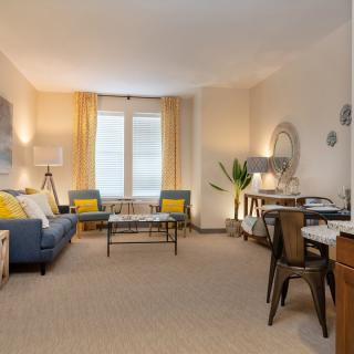 A cozy living room featuring modern decor with a sofa, coffee table, and various decorative elements.