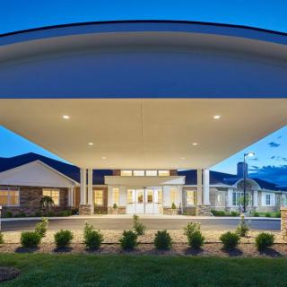 A modern building entrance illuminated at night with well-maintained landscaping.