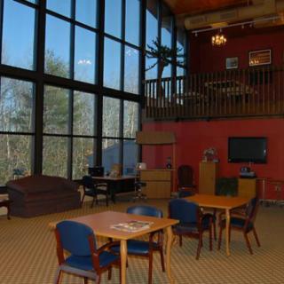 A spacious lounge area with large windows and modern furniture.
