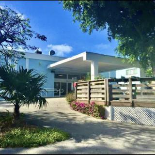 A modern architectural structure surrounded by greenery and blooming flowers.