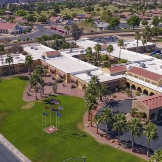 Aerial view of a suburban area with palm trees and large buildings.