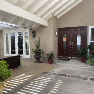 A welcoming house entrance with potted plants and outdoor seating.