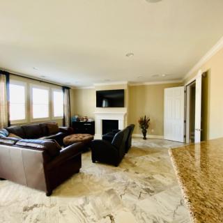 A modern living room with a cozy seating area, a fireplace, and a mounted television.