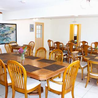A spacious dining room featuring wooden tables and chairs, perfect for gatherings.