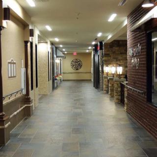 A well-lit hallway with brick walls and tiled flooring.