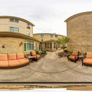 A spacious outdoor patio with comfortable seating in a courtyard setting.