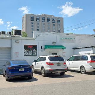 A view of a parking lot with several cars parked outside a multi-story building.