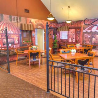 A cozy indoor cafe with decorative wall art and neatly arranged tables and chairs.